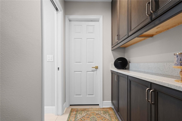 doorway to outside featuring light tile patterned floors and baseboards