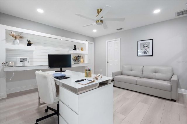 office area with ceiling fan, visible vents, baseboards, and light wood-style floors