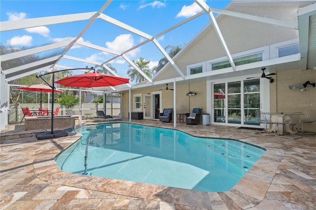 view of swimming pool with a fenced in pool, a patio, ceiling fan, and glass enclosure