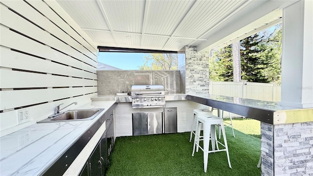 view of patio with grilling area, a sink, outdoor wet bar, and area for grilling
