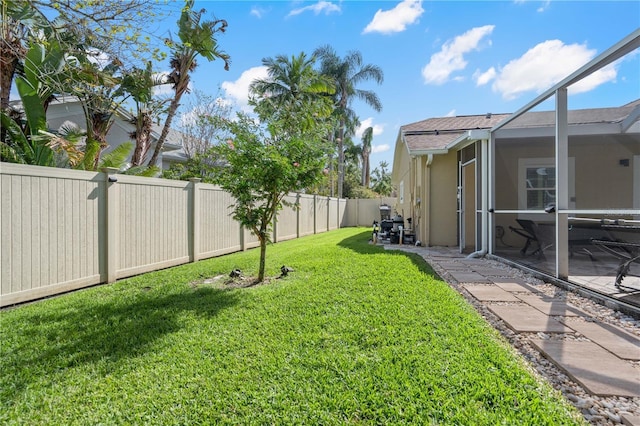 view of yard with a patio, a lanai, and a fenced backyard