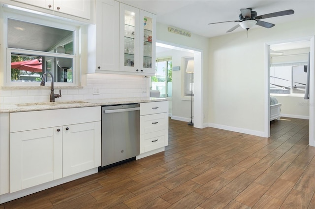 kitchen featuring a sink, tasteful backsplash, dark wood-type flooring, and stainless steel dishwasher
