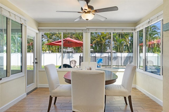 sunroom featuring baseboards and wood finish floors