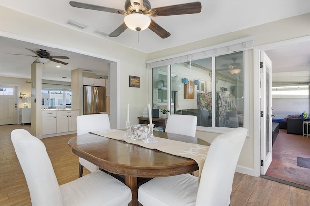 dining area with visible vents, light wood-style floors, and a ceiling fan