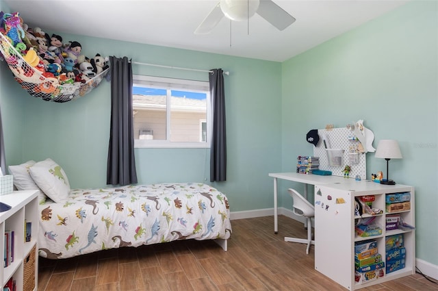 bedroom with baseboards, ceiling fan, and wood finished floors