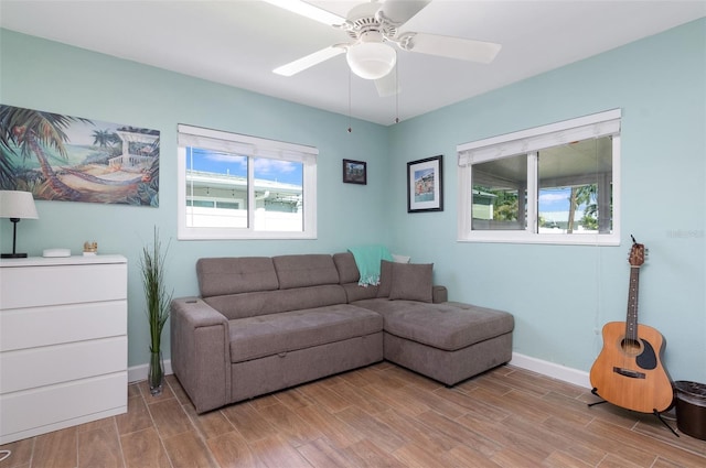 living area featuring baseboards, wood tiled floor, and a ceiling fan
