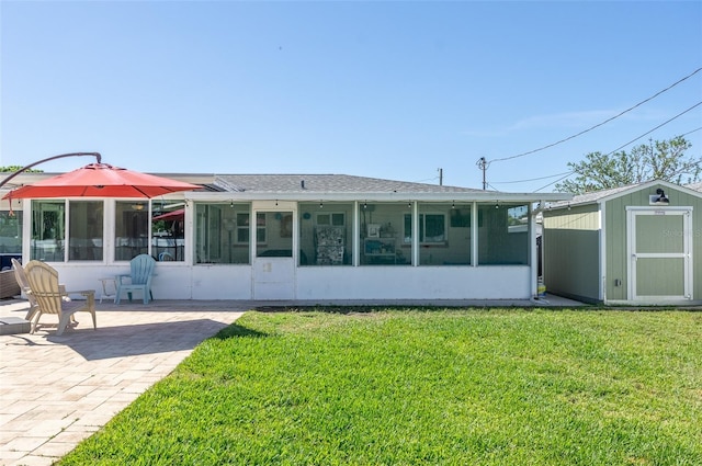 back of house featuring a patio, a sunroom, a lawn, and a shed