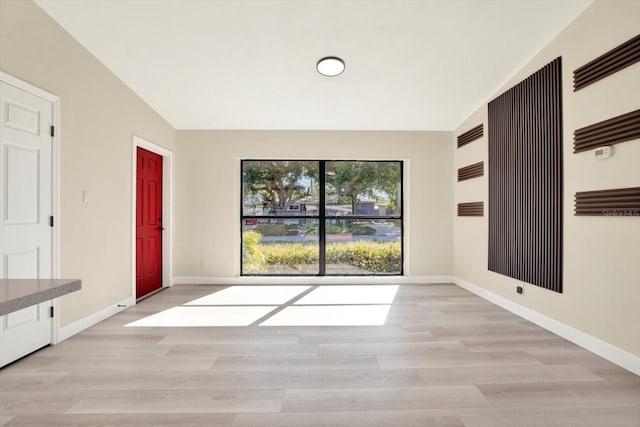 empty room with baseboards and light wood-style floors