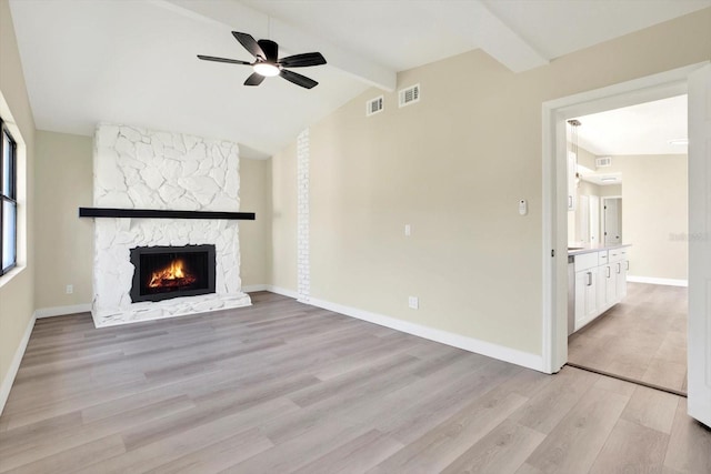unfurnished living room with baseboards, light wood-type flooring, a fireplace, a ceiling fan, and visible vents