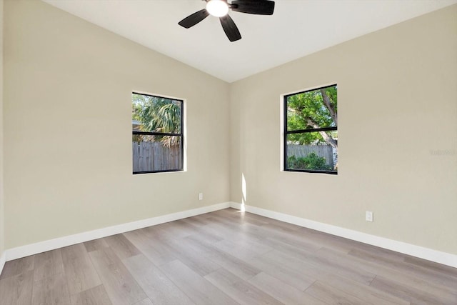 spare room featuring lofted ceiling, ceiling fan, baseboards, and wood finished floors