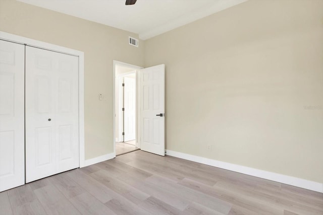 unfurnished bedroom featuring light wood-style floors, visible vents, a closet, and baseboards
