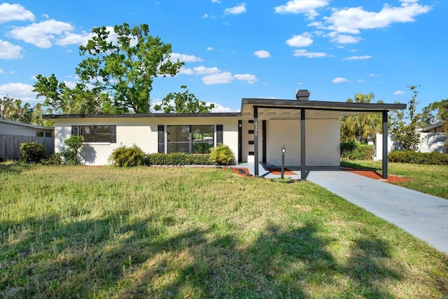 view of front of house with stucco siding, fence, and a front lawn