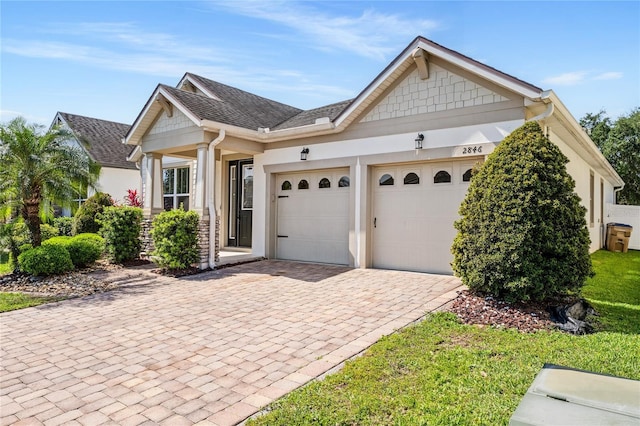 view of front of house featuring decorative driveway, a garage, and stucco siding