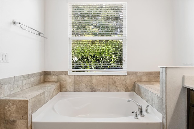 bathroom featuring a wealth of natural light, vanity, and a bath