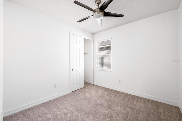 unfurnished bedroom featuring carpet floors, baseboards, a ceiling fan, and a closet