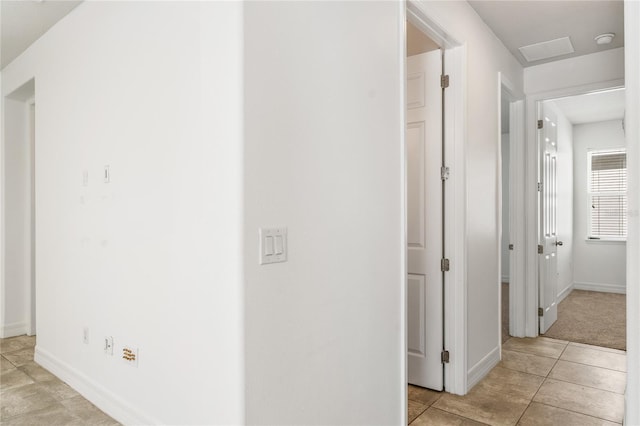 hall with light tile patterned floors and baseboards