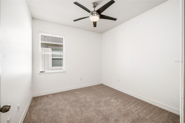 empty room featuring carpet flooring, baseboards, and a ceiling fan