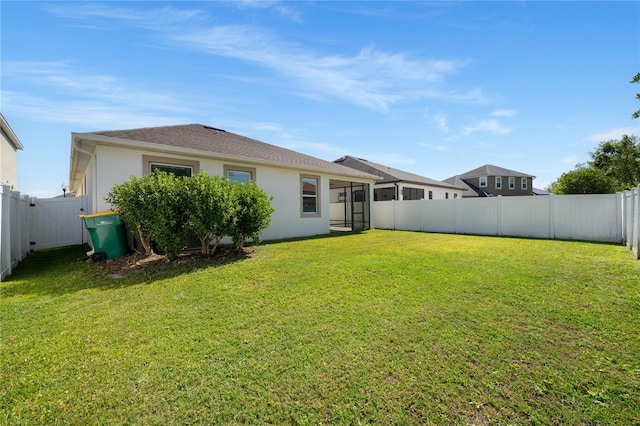 back of house with a yard, a fenced backyard, and stucco siding