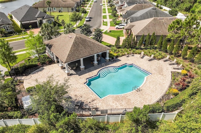 pool with a residential view, a patio area, and fence