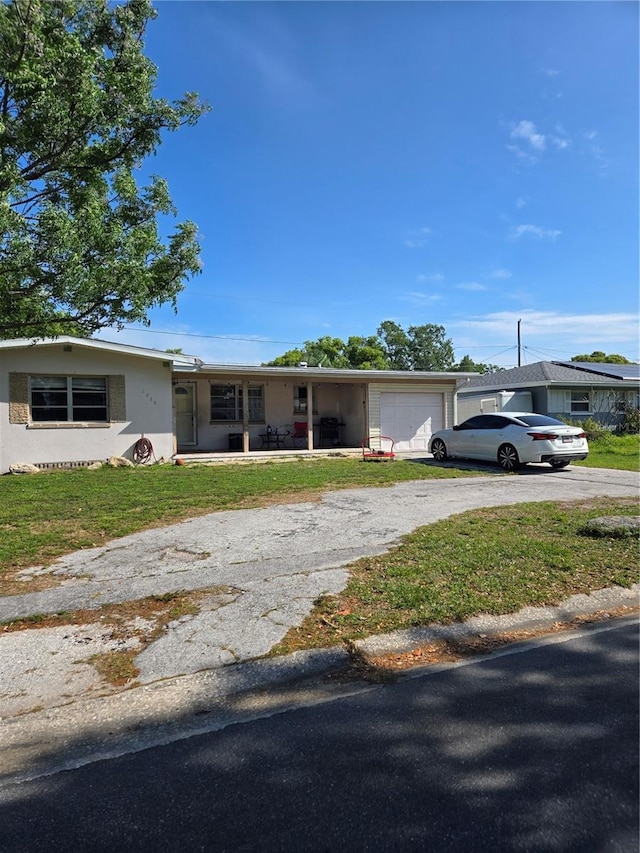 view of front facade featuring driveway, an attached garage, a front yard, and a porch