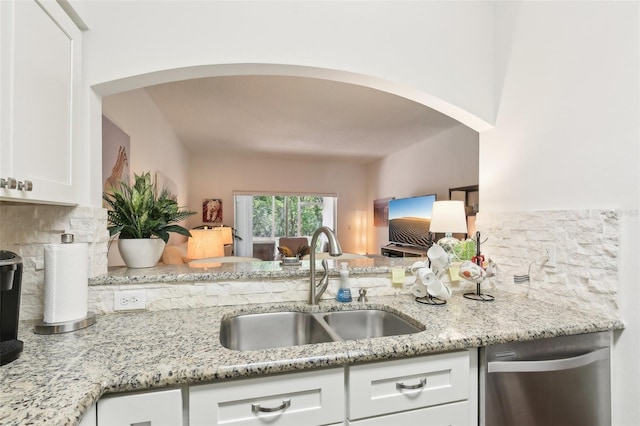 18187 Paradise Point Dr, Tampa, FL 33647 - kitchen with stainless steel dishwasher, a sink, arched walkways, and decorative backsplash