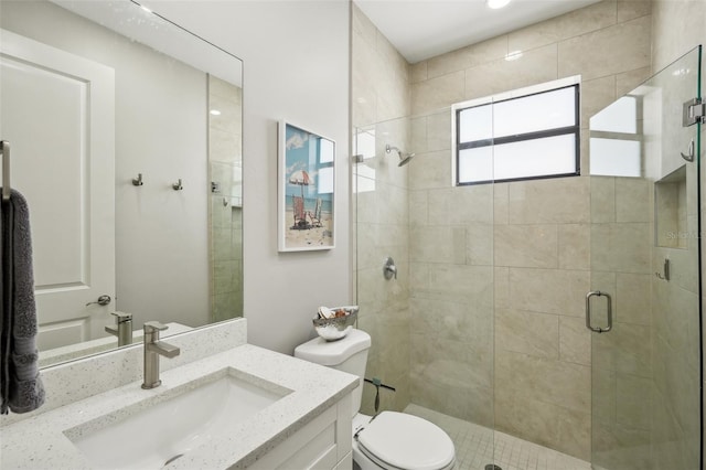 full bathroom featuring a shower stall, toilet, and vanity