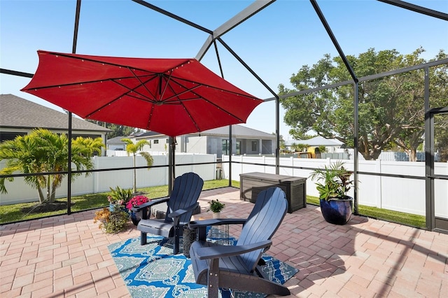 view of patio / terrace featuring a fenced backyard and glass enclosure