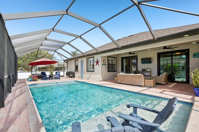 pool with a ceiling fan, glass enclosure, an outdoor living space, and a patio area
