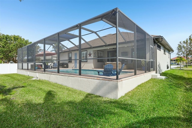 rear view of house with glass enclosure, an outdoor pool, stucco siding, and a lawn