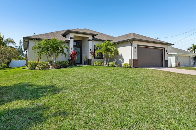 prairie-style house with a front yard, stucco siding, an attached garage, and concrete driveway