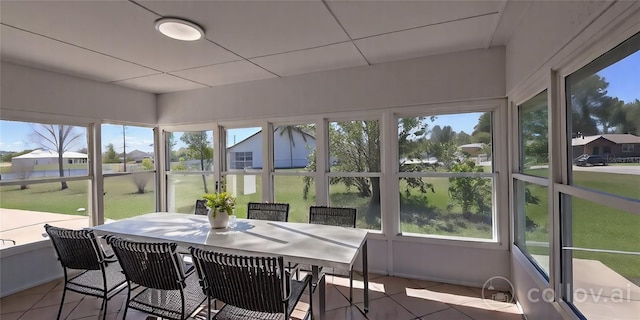 sunroom / solarium featuring outdoor dining area and a healthy amount of sunlight