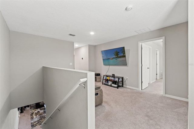 12856 French Market Dr, Riverview, FL 33579 - hallway featuring a textured ceiling, an upstairs landing, visible vents, carpet, and baseboards