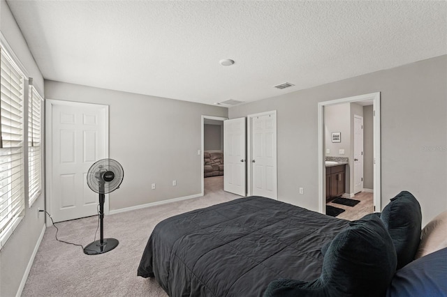 12856 French Market Dr, Riverview, FL 33579 - bedroom featuring a textured ceiling, ensuite bathroom, baseboards, light colored carpet, and visible vents