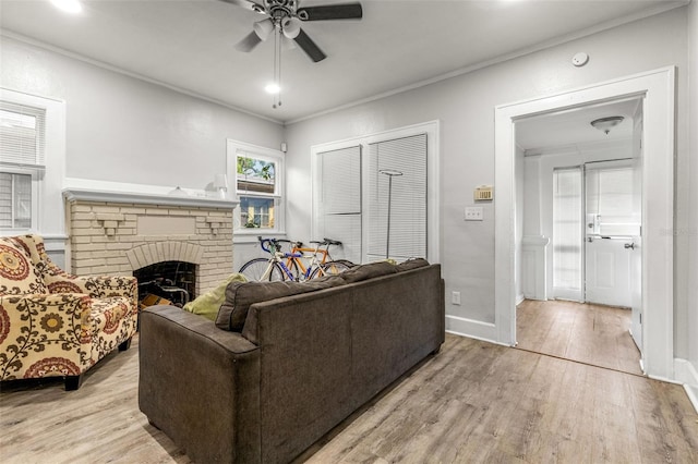 1134 9th Ave S, Saint Petersburg, FL 33705 - living area featuring a fireplace, ornamental molding, a ceiling fan, and light wood finished floors