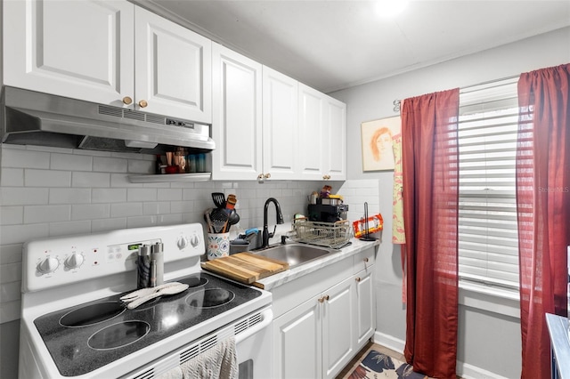 1134 9th Ave S, Saint Petersburg, FL 33705 - kitchen with decorative backsplash, white cabinets, under cabinet range hood, a sink, and white range with electric stovetop