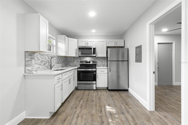 1134 9th Ave S, Saint Petersburg, FL 33705 - kitchen featuring a sink, white cabinetry, light countertops, and appliances with stainless steel finishes