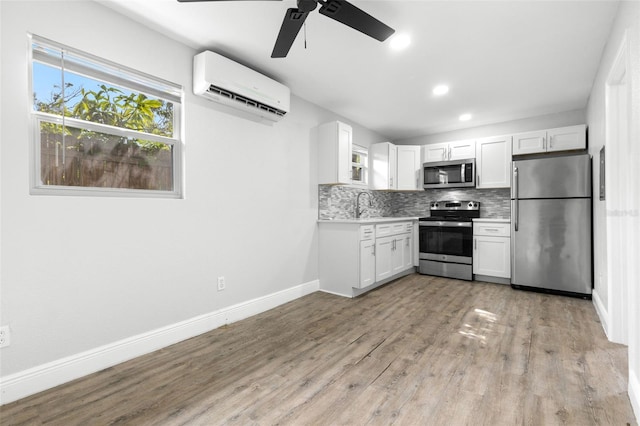 1134 9th Ave S, Saint Petersburg, FL 33705 - kitchen featuring backsplash, light wood-style flooring, stainless steel appliances, an AC wall unit, and ceiling fan