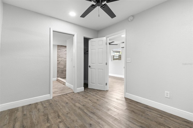 1134 9th Ave S, Saint Petersburg, FL 33705 - unfurnished bedroom featuring ensuite bathroom, baseboards, ceiling fan, wood finished floors, and a textured wall