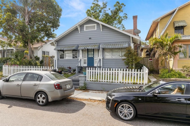 1134 9th Ave S, Saint Petersburg, FL 33705 - bungalow-style house with a chimney and a fenced front yard