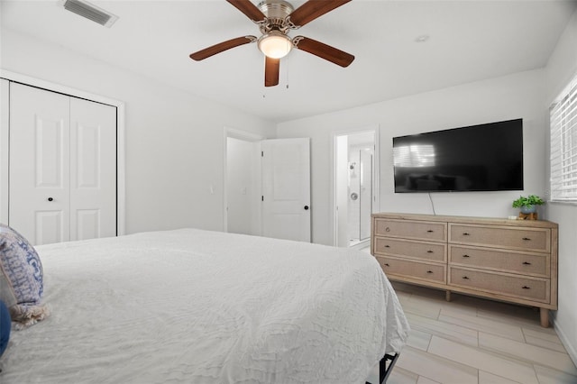 bedroom featuring visible vents, ceiling fan, a closet, and ensuite bath