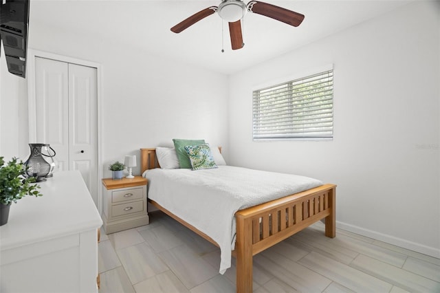 bedroom with a closet, baseboards, and a ceiling fan