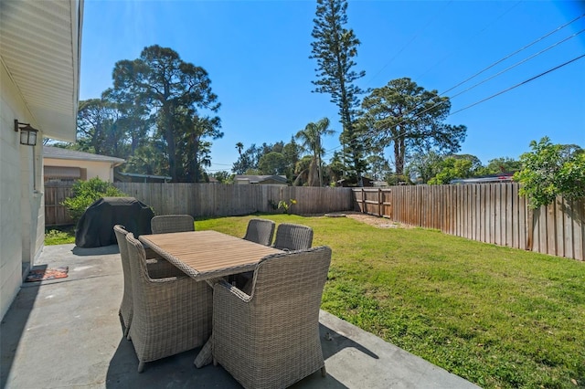 view of yard with a patio area, a fenced backyard, and outdoor dining area