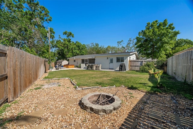view of yard featuring an outdoor fire pit, a fenced backyard, and a patio area
