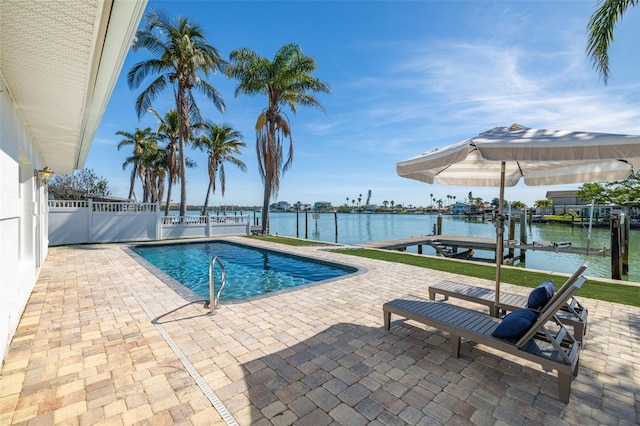 pool with a water view, fence, a dock, and a patio area