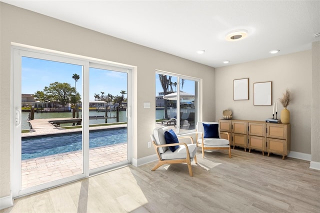 living area featuring baseboards, light wood-style flooring, and recessed lighting