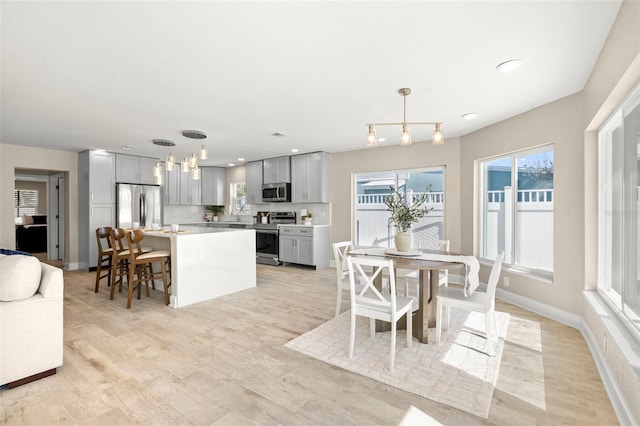 dining area featuring baseboards, light wood-style floors, and recessed lighting