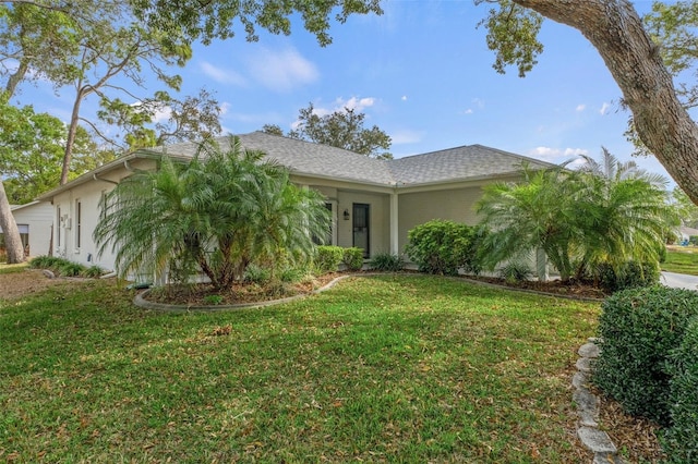 view of front of house with stucco siding and a front lawn