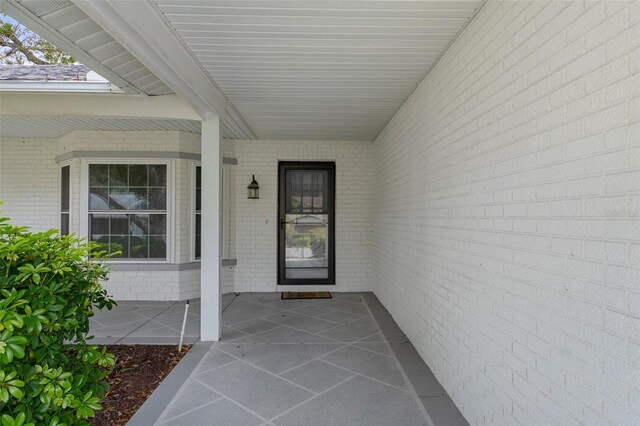 view of exterior entry featuring brick siding