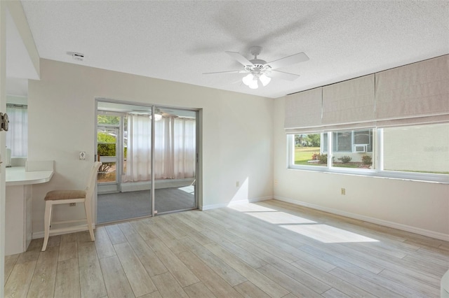 unfurnished bedroom featuring baseboards, a textured ceiling, access to exterior, and wood finished floors