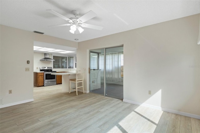 living area featuring baseboards, visible vents, light wood-style floors, and a ceiling fan